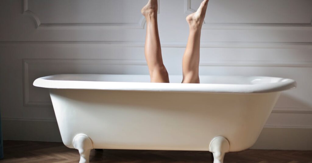 Artistic photo showing legs playfully sticking out of a classic bathtub in a stylish bathroom.