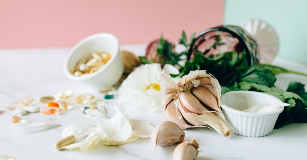Flat lay of garlic, supplements, and herbs showcasing natural remedies on a marble surface.