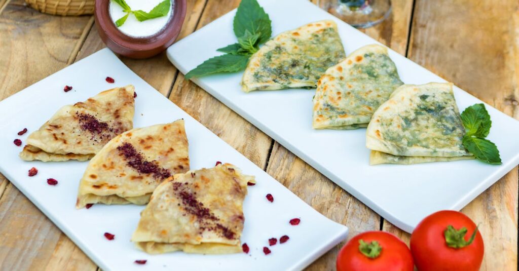 Delicious Azerbaijani Qutab served with fresh herbs and tomato on a rustic wooden table.